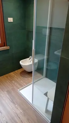 a bathroom with a toilet and a glass shower at Casa Dolomite in Mezzano