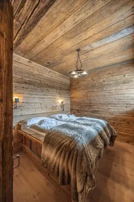 a bedroom with wooden walls and a large bed at Casa Aquila, con sauna privata in Chiave