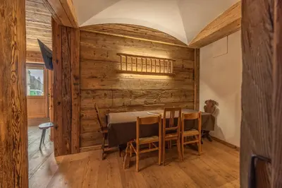 a dining room with wooden walls and a table and chairs at Casa Aquila, con sauna privata in Chiave