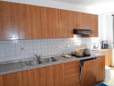 a kitchen with wooden cabinets and a sink at Chalet Pradat in Arabba