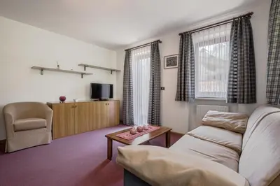 a living room with a couch and a chair at Chalet Pradat in Arabba