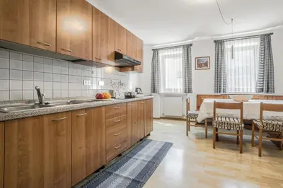 a kitchen with wooden cabinets and a dining room at Chalet Pradat in Arabba