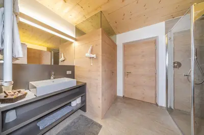 a bedroom with a bed and a mountain mural on the wall at Garni Tramans in Selva di Val Gardena