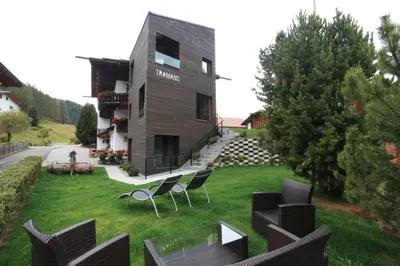 a black and white building with flowers on the balconies at Garni Tramans in Selva di Val Gardena
