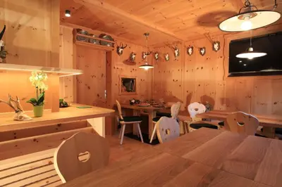 a dining room with wooden walls and a table and chairs at Garni Tramans in Selva di Val Gardena