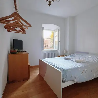 a white bedroom with a bed and a window at El Me Popo in Segonzano
