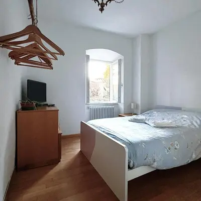 a white bedroom with a bed and a window at El Me Popo in Segonzano