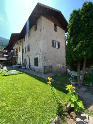 a large stone building with a grass yard at El Me Popo in Segonzano