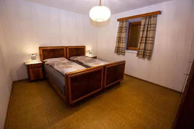 a bedroom with a wooden bed with two night stands at Gatscherhof Retreat - Family Appartement in Chienes