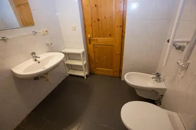 a bathroom with a toilet and a sink at Gatscherhof Retreat - Family Appartement in Chienes
