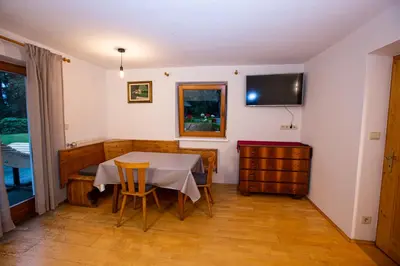 a dining room with a table and a tv on the wall at Gatscherhof Retreat - Family Appartement in Chienes