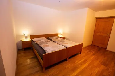 a bedroom with two beds and two lights on two tables at Gatscherhof Retreat - Family Appartement in Chienes