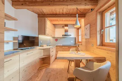 a kitchen with wooden cabinets and a wooden table at The Love Chalet in Falcade