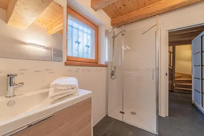 a bathroom with a shower and a toilet and a sink at The Love Chalet in Falcade