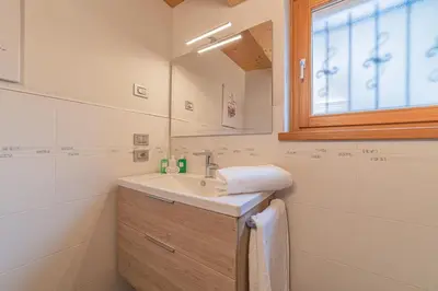 a bathroom with a washing machine and a toilet at The Love Chalet in Falcade