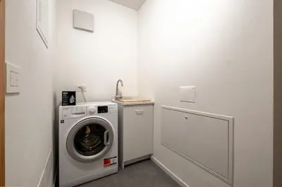 a laundry room with a washing machine and a sink at Cèsa Cercenà in Canazei
