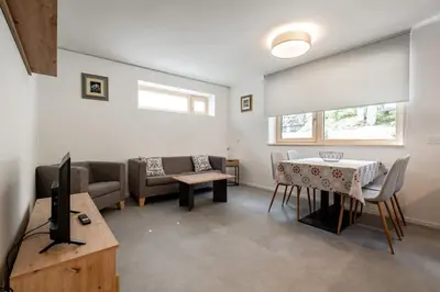 a living room with a couch and a table at Cèsa Cercenà in Canazei