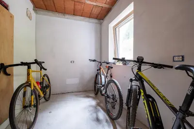 three bikes parked in a room with a window at Cèsa Cercenà in Canazei