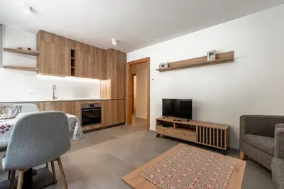 a living room with a television and a table and chairs at Cèsa Cercenà in Canazei