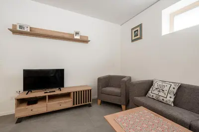 a living room with a couch and a tv at Cèsa Cercenà in Canazei