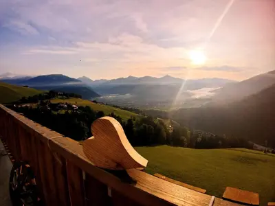 a wooden bench sitting on top of a mountain at Bärenhotel in Valdaora