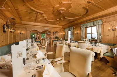 a dining room with white tables and chairs at Bärenhotel in Valdaora