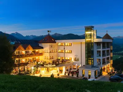 a large white building with lights on at night at Bärenhotel in Valdaora