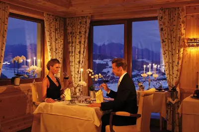 a man and woman sitting at a table in a restaurant at Bärenhotel in Valdaora