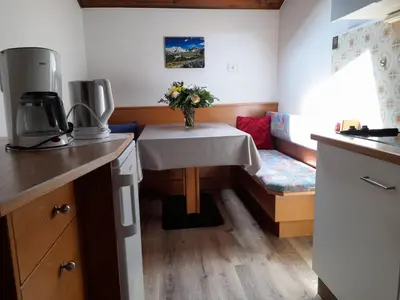 a kitchen with a table and a couch with flowers on it at Appartament Alpenheim in Ferrara