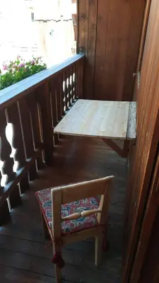 a wooden porch with a bench and a table at Casa Falco in Cortina dʼAmpezzo