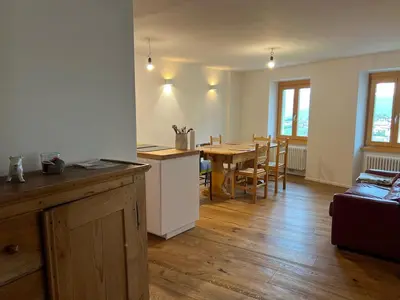 a kitchen and dining room with a table and chairs at Ciasa dei Pomi Apartment in Sfruz