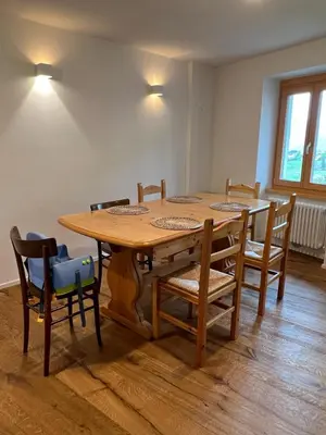 a wooden table and chairs in a room at Ciasa dei Pomi Apartment in Sfruz
