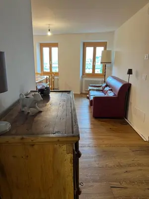 a living room with a couch and a table at Ciasa dei Pomi Apartment in Sfruz