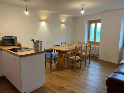 a kitchen and dining room with a table and chairs at Ciasa dei Pomi Apartment in Sfruz