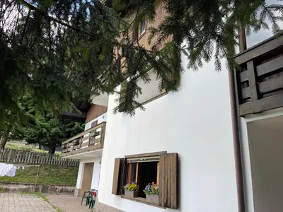 a white building with a window with flowers in it at Ca' Virginia - Val di Fassa in Vigo di Fassa