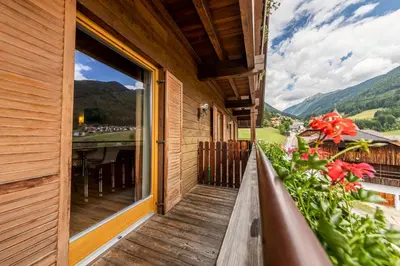a balcony of a house with a view of the mountains at Hotel Rommisa in Perca