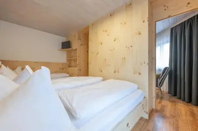 two white beds in a room with a window at Mountain Vibes Colfosco in Colfosco