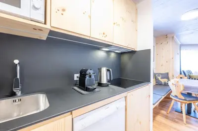 a kitchen with a sink and a coffee maker on the counter at Mountain Vibes Colfosco in Colfosco
