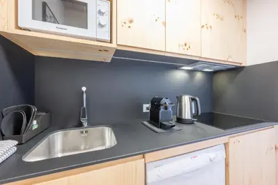 a kitchen with a sink and a microwave at Mountain Vibes Colfosco in Colfosco