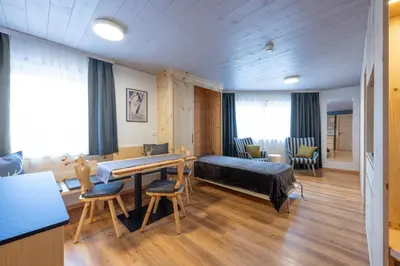 a room with a bed and a table and chairs at Mountain Vibes Colfosco in Colfosco