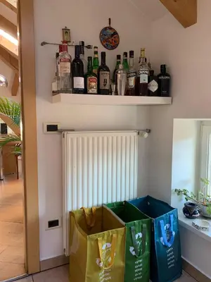 a shelf with bottles of alcohol on a wall at Sunflower House in Bolzano