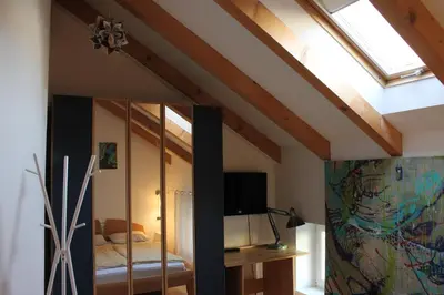 a bedroom with a skylight and a mirror at Sunflower House in Bolzano