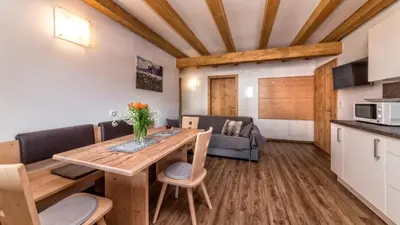 a kitchen and dining room with a table and chairs at Appartement Treffpunkt in Molini di Tures