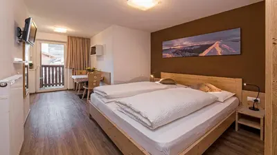 a bedroom with a bed with a dog laying on it at Appartement Treffpunkt in Molini di Tures