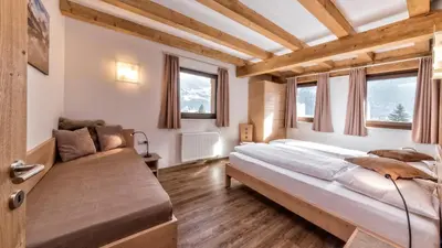 a bedroom with a large bed and a couch at Appartement Treffpunkt in Molini di Tures