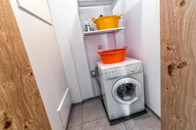 a washing machine with an orange bucket on top of it at Appartement Treffpunkt in Molini di Tures