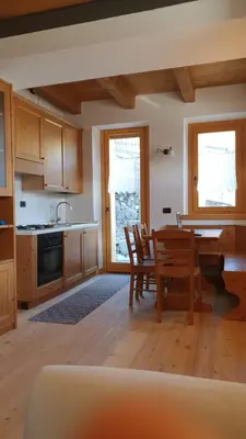 a kitchen and dining room with a table and chairs at Sunny and cosy holiday apartment in the Dolomites in Pianaz