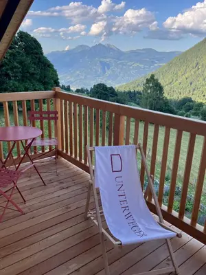 a chair on a deck with a table and a view at Berg Apartment Vajolet - Unterweger Berg Apartments in Tisens