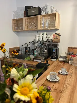 a kitchen with a wooden table with cups and flowers at Berg Apartment Vajolet - Unterweger Berg Apartments in Tisens