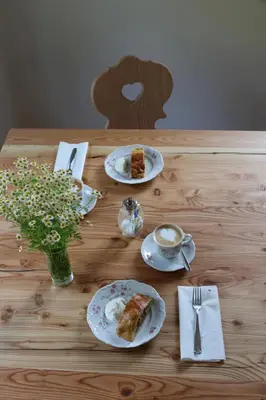 a table with plates of food and a cup of coffee at Berg Apartment Vajolet - Unterweger Berg Apartments in Tisens